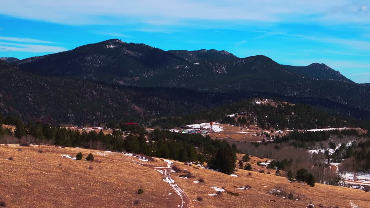 Central City Parkway Black Hawk Idaho Springs Gilpin County aerial drone Colorado winter snow historic Gold mining town highway blue sky sunny clouds Rocky Mountains Power lines circle right motion