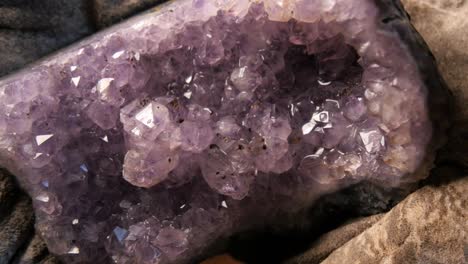 las manos del geólogo sosteniendo el mineral de cristal de ametista de la mina