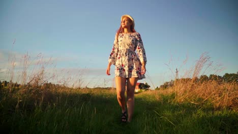 Stunning-HD-footage-of-a-beautiful-young-woman-in-a-dress,-wearing-a-knitted-hat-and-red-lipstick,-joyfully-walking-through-a-wheat-field