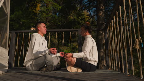 couple immerses in meditative harmony on board floor. partners spend vacation dedicated to personal growth using yoga practice on floor among nature