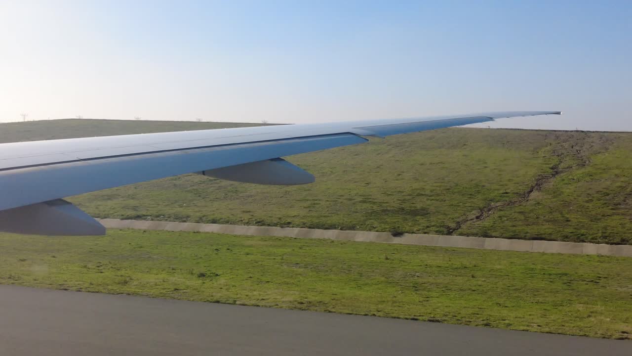 крыло самолета над взлетно-посадочной полосой аэропорта