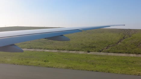 airplane wing over airport runway