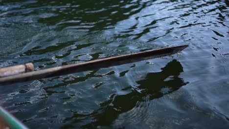 Primer-Plano-De-Remo-De-Madera-En-El-Río-Remando-En-Cámara-Lenta