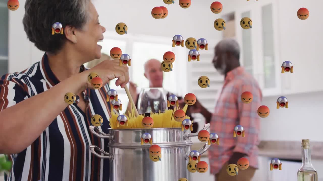 Multiple face emojis floating against african american senior woman cooking spaghettis at home