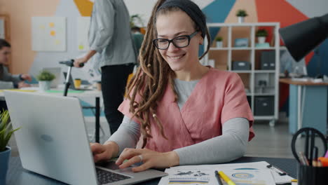 mujer trabajando en una computadora portátil en una oficina moderna