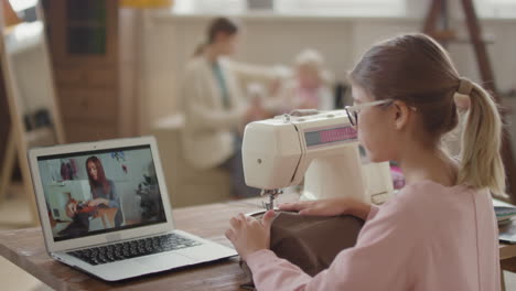 girl learning to sew online with a video tutorial