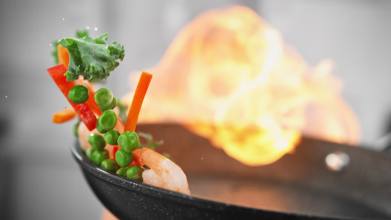 아시아 음식 요리 - 채소와 함께 새우를 김판에 던져서 느린 동작으로 불에 습니다.