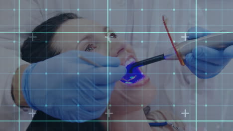 líneas de cuadrícula contra el dentista que trata a una paciente femenina