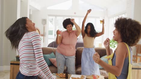 happy diverse female friends dancing together and smiling in living room