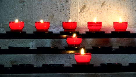 candles burn in candlesticks on the shelves in the temple