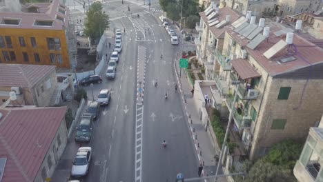 aerial clip of children racing downhill using bikes and go kart