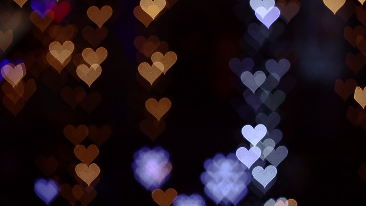 4k uhd video de fondo para el día de san valentín. frontera con bokeh de corazones románticos brillantes y relucientes en un fondo negro. amor, bokeh en forma de corazón.