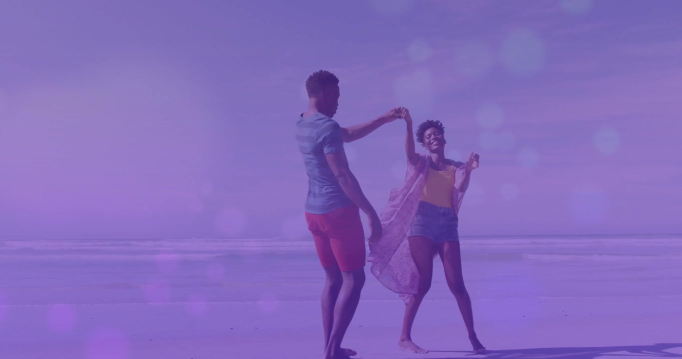 ライフスタイルを表現する、日当たりの良いビーチで踊るカップル。男性が手を上げて、カバーアップがふわりと舞うスピンを始める