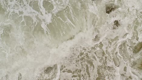 top down view ocean waves over rocks in slow motion at banbanon beach in the philippines