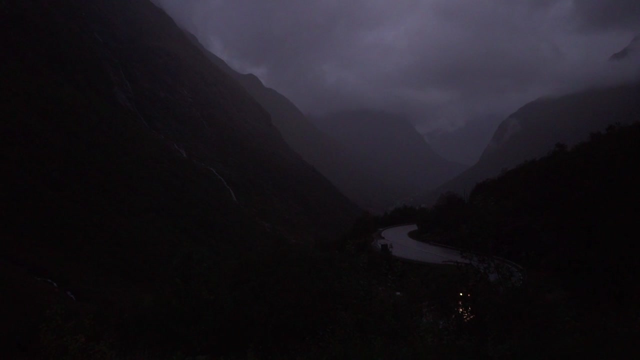 어두운 산으로 운전하는 외로운 차