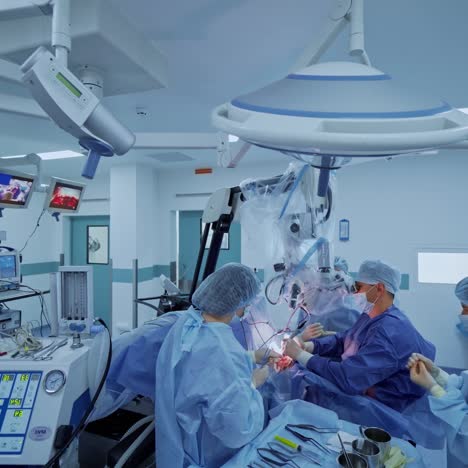 teamwork of doctors in operating theater. medical workers in blue uniform operate the patient using new technologies in neurosurgery.