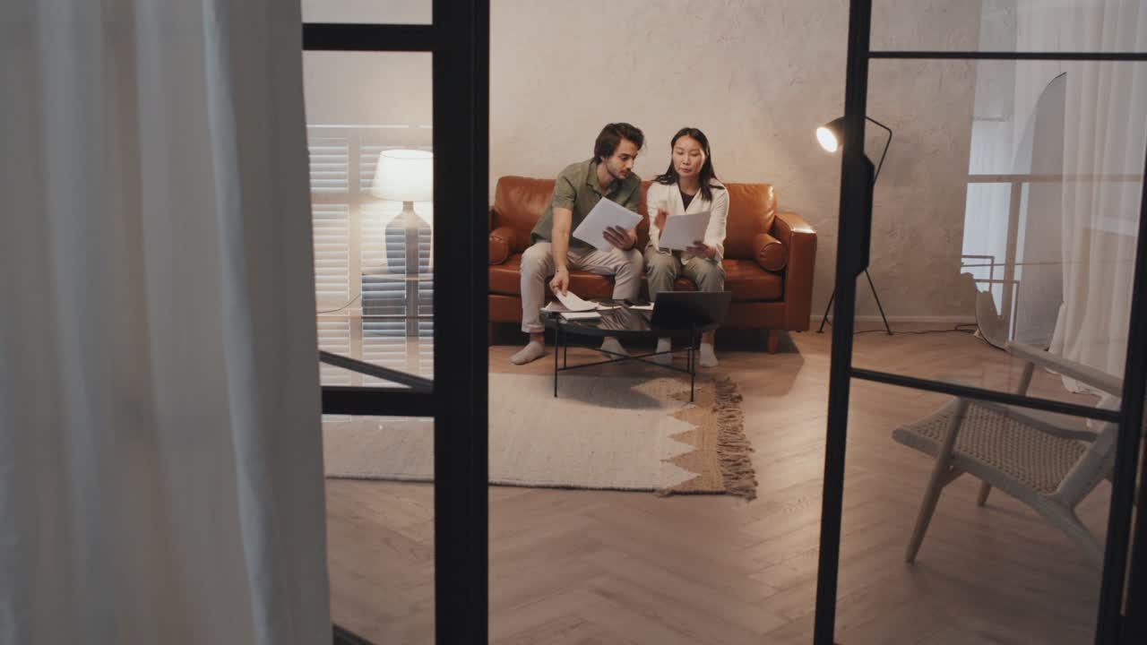 부부가 거실 에서 예산 에 대해 논의 하고 있다