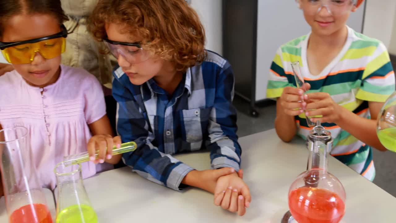 maestro de escuela ayudando a los niños de la escuela en un experimento químico en el laboratorio