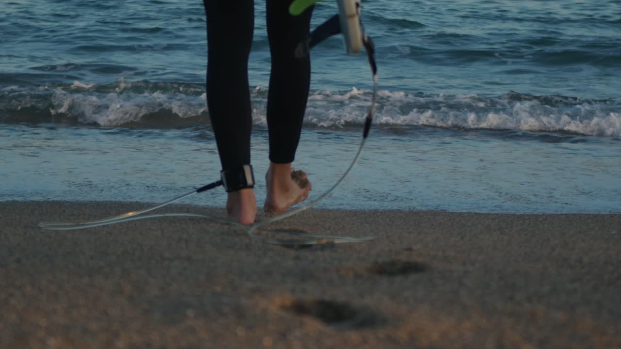 Surfer man walking to the beach at sunset preparing for surfing training and search for waves in Barcelona, spain, water, ocean exercise in sea with board, athletic male holiday or travel in vacation