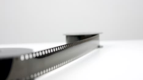 película antigua de 8 mm sobre mesa blanca, empuje lento hacia atrás