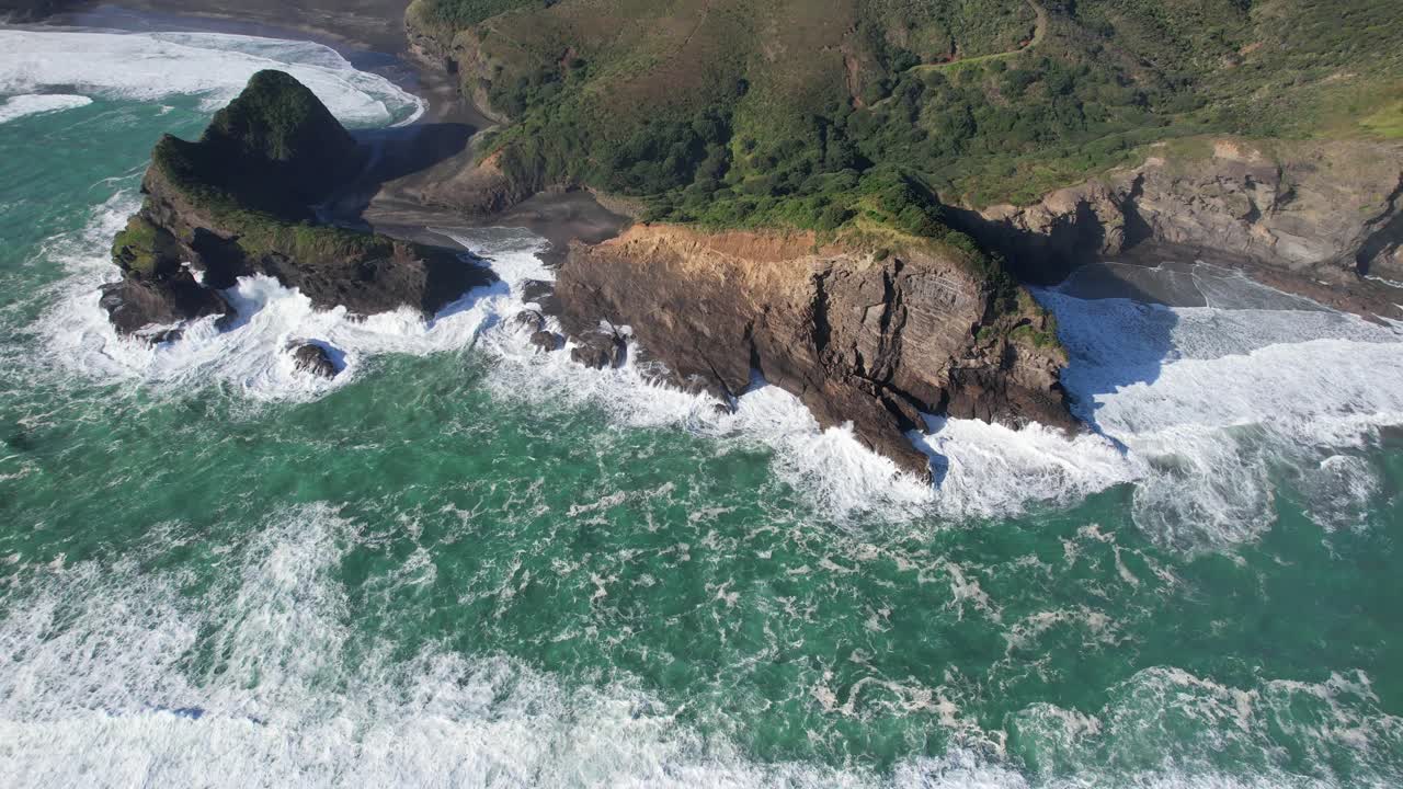 Ilmakuva Taitomo-saaren aukosta ja Puaotetai-lahden kallioista lähellä Piha Beachia, Uusi-Seelanti.