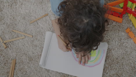 child drawing a rainbow