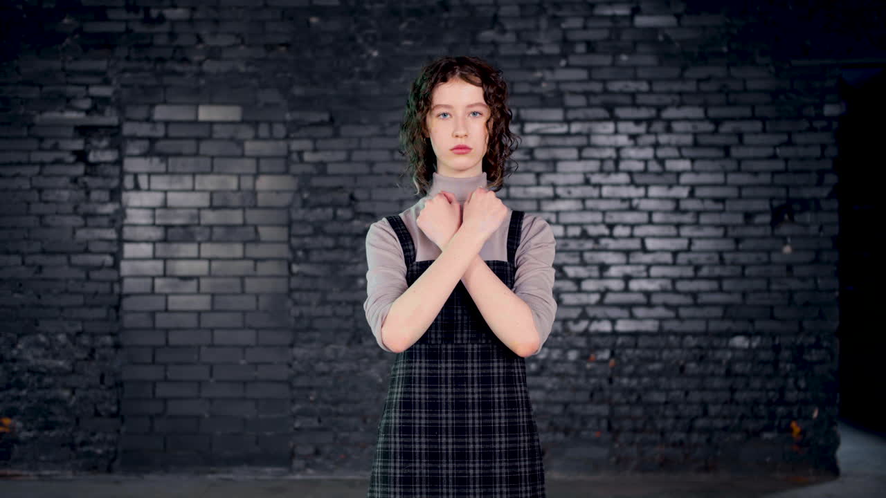 진지한 젊은 환경 운동가가 카메라를 보고 녹색 "비문"으로 팔을 보여주고 있습니다.