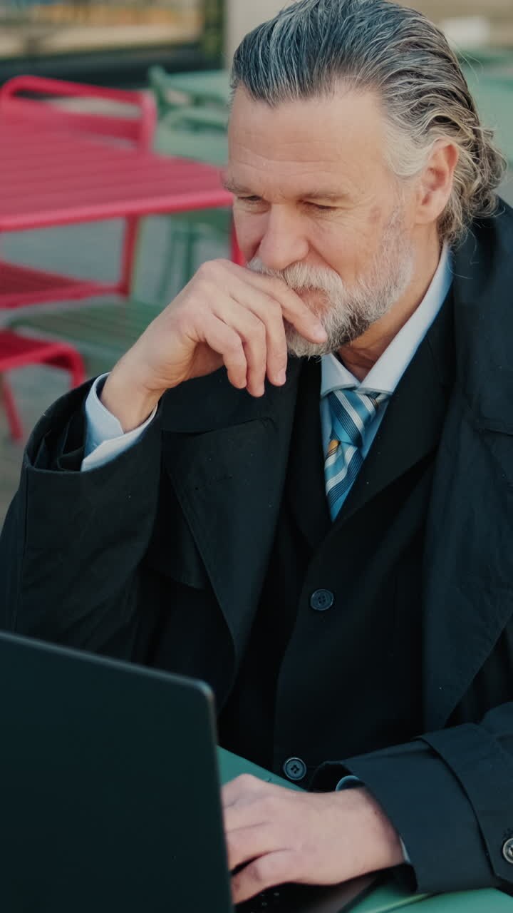 Businessman Working on Laptop at Outdoor Cafe