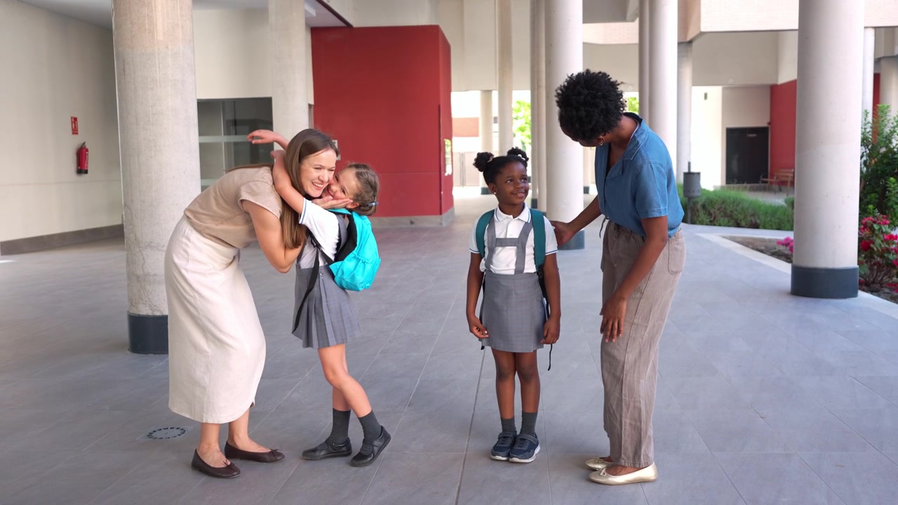 Mothers Dropping Off Young Daughters at School
