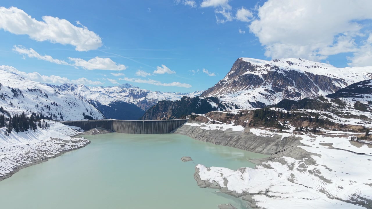 Ripresa aerea in allontanamento sopra la diga del bacino idrico di Kops in Tirolo in inverno