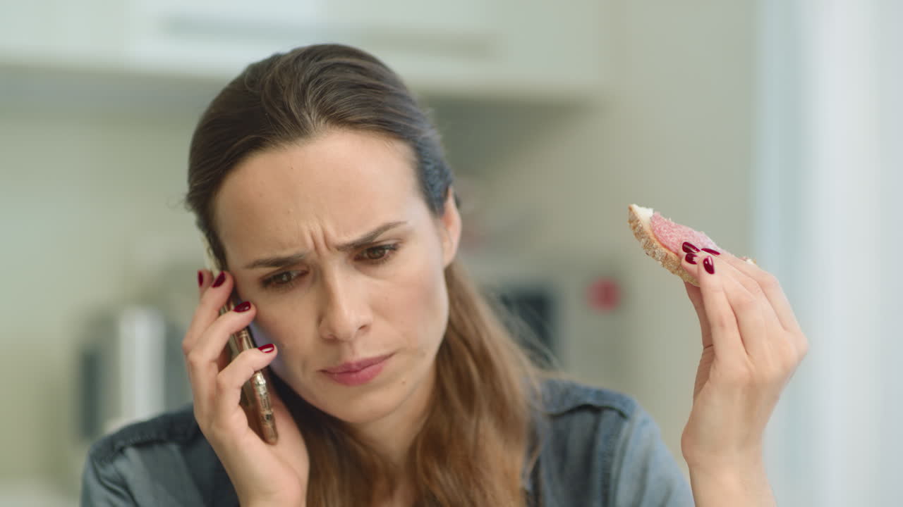 Closeup woman getting bad news. rustrated girl talking phone in living room.