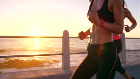 two-friends-jogging-on-the-promenade-at-sunset