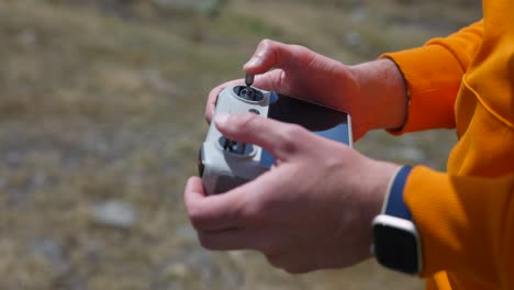 Closeup-of-drone-pilot-holding-and-controlling-flying-movements-using-controller