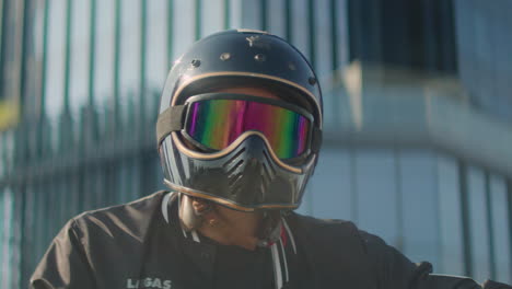 person wearing a motorcycle helmet with rainbow goggles