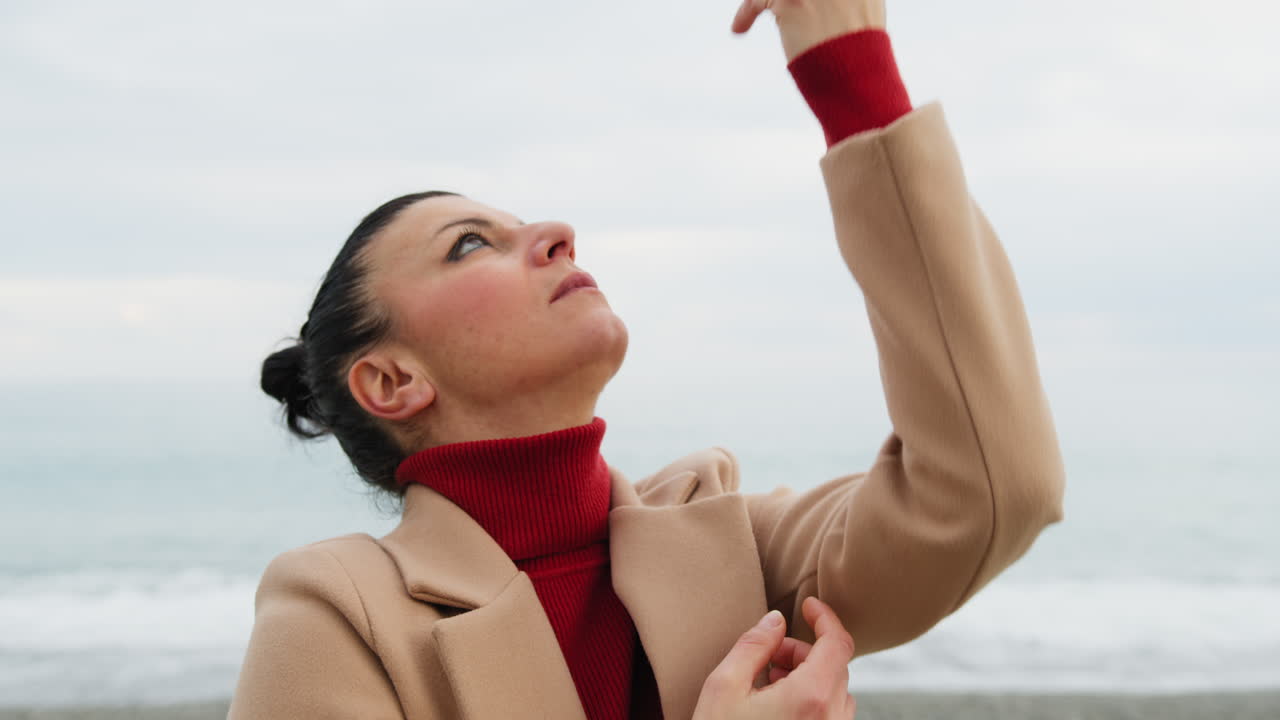 Near the Ocean A Woman Moves Her Hands on Her Face to the Rhythm of a Slow