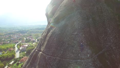 Hermosa-Antena-Mientras-Los-Escaladores-Ascienden-Por-Un-Escarpado-Acantilado-Rocoso-En-Meteora,-Grecia-1