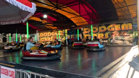 personas disfrutando de coches de parachoques en una feria de diversión