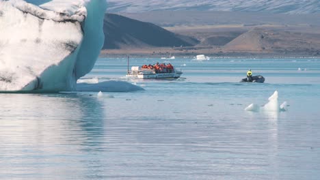 cruise boat with tourists in life jackets in arctic sea with icebergs