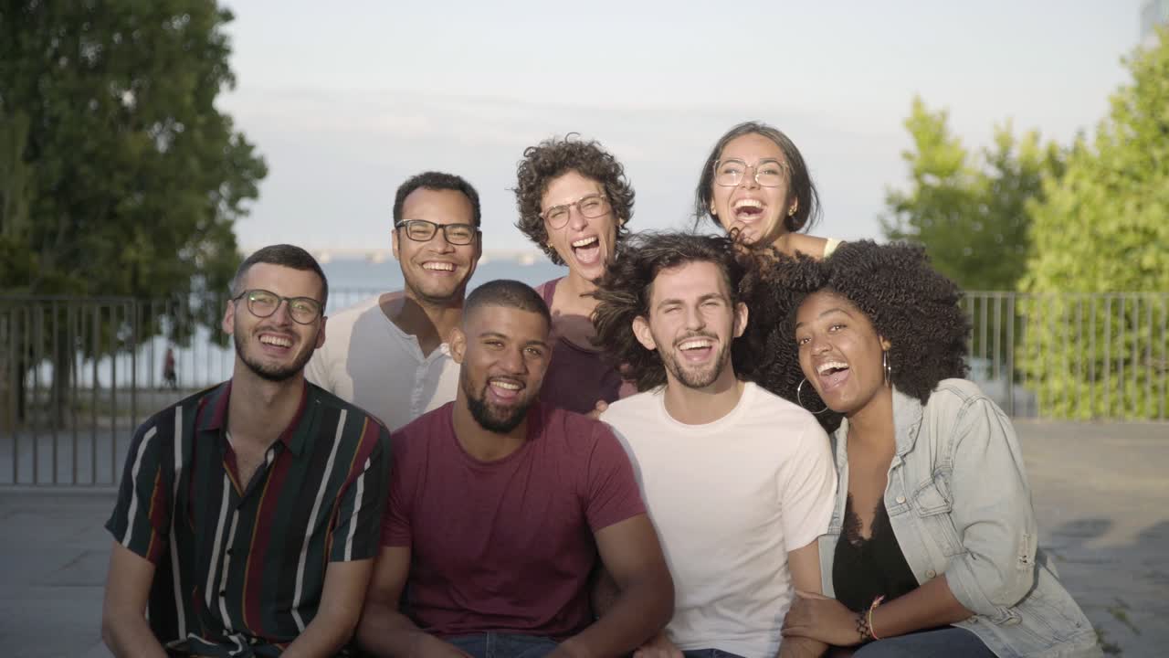 amigos felices hablando mientras están sentados en un banco en el parque