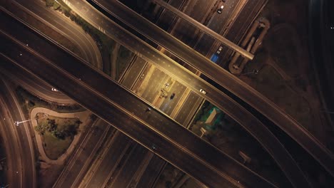 transporte de tráfico de automóviles en la intersección de carreteras en la ciudad de bangkok, tailandia por la noche. transporte público, estilo de vida de los viajeros, concepto de vida de la ciudad asiática. vista aérea de drones