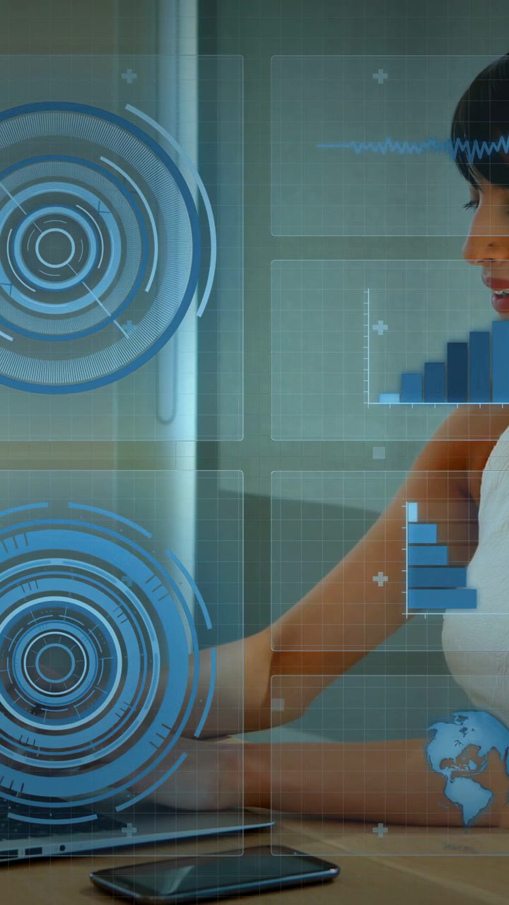 Vertical video: Woman typing laptop causing HUD animating, picking phone and analyzing tech data