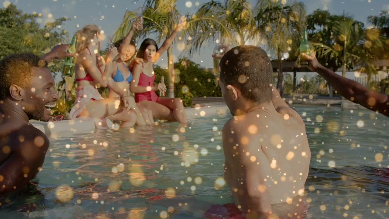 Donne a bordo piscina che alzano una bottiglia per brindare, uomini che le imitano, con una sovrapposizione scintillante su tutto il fotogramma per il marketing.