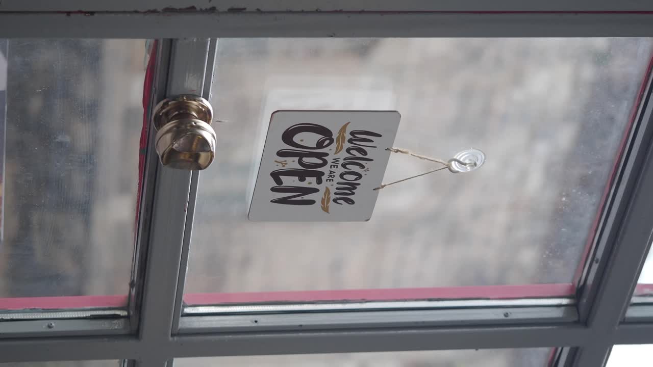 An open sign hanging in a window