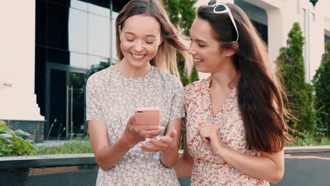 two happy friends looking at a phone