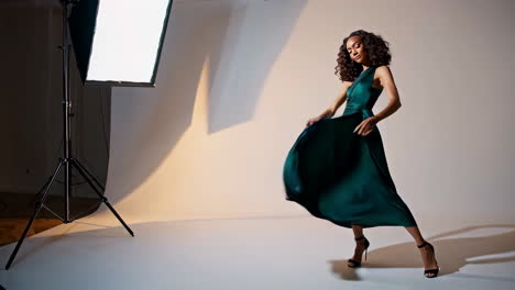 woman in a green satin dress in studio