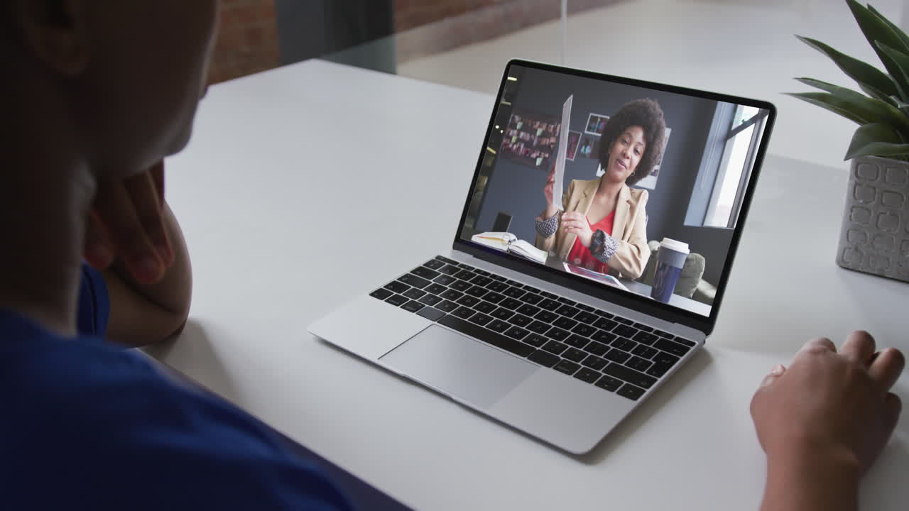 Mid section of african american woman having a video call with female colleague on laptop at office