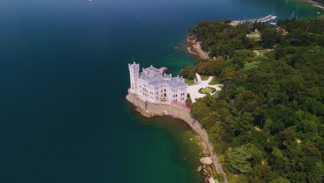 a través de la lente de una cámara drone, uno puede apreciar la majestuosa belleza del castillo de miramare, elegantemente encaramado por el mar