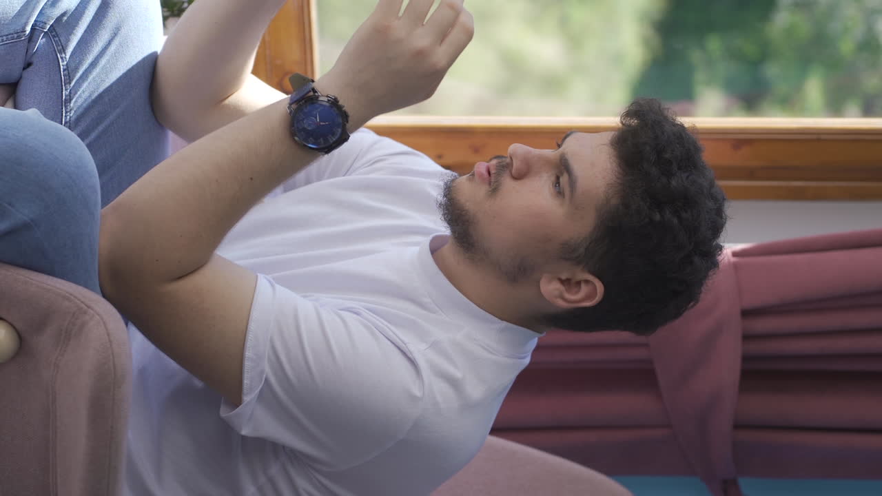 video vertical de un hombre decepcionado enviando mensajes de texto.