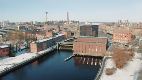 ascending drone footage of the rapids and dam in the city center of tampere