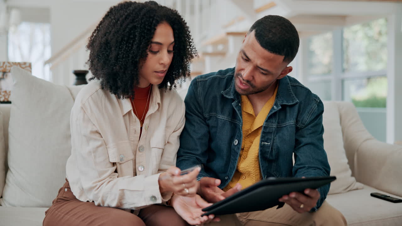Couple planning finances at home using tablet